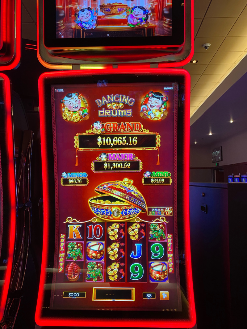 Dancing Drums slot machine in a casino with features including grand, major, minor and mini showing